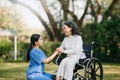 Elderly asian senior woman on wheelchair with Asian careful caregiver. Nursing home hospital garden concept. in sun light Royalty Free Stock Photo
