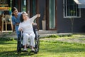 Elderly asian senior woman on wheelchair with nurse. Nursing home hospital garden concept. Royalty Free Stock Photo