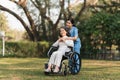 Elderly asian senior woman on wheelchair with nurse. Nursing home hospital garden concept. Royalty Free Stock Photo