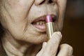 Elderly asian woman applied lipstick