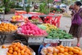 Elderly Asian woman chooses fruit in the bazaar