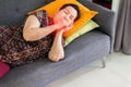 Elderly Asian woman coughing and lying on sofa at home,Female sore throat,Concept of health