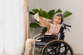 Elderly asian woman doing stretching exercise on wheelchair in living room at home Royalty Free Stock Photo