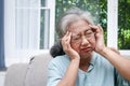 An elderly Asian woman has a headache, feels sick.