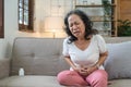 Elderly asian woman having painful from stomach ache at home,Senior female suffering with abdominal pain Royalty Free Stock Photo