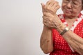 Elderly Asian woman patients suffer from numbing pain in hands from rheumatoid arthritis. Senior woman massage her hand with wrist