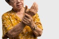 Elderly Asian woman patients suffer from numbing pain in hands from rheumatoid arthritis. Senior woman massage her hand with wrist Royalty Free Stock Photo