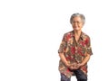 An elderly Asian woman sitting on a chair, smiling, and looking at the camera with a white background. Photo in the studio. Space Royalty Free Stock Photo