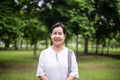 Elderly asian woman standing and looking camera at park,Happy and smiling face Royalty Free Stock Photo