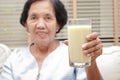 Elderly Asian women drink milk containing calcium to prevent osteoporosis.