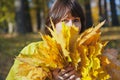 Elderly attractive woman hiding her face behind armful yellow au