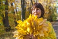 Elderly attractive woman hiding her face behind armful yellow au