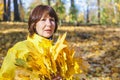 Elderly attractive woman hiding her face behind armful yellow au