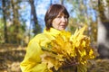 Elderly attractive woman hiding her face behind armful yellow au