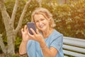 Elderly attractive woman with smartphone outdoor