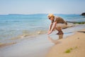 Elderly attractive woman touching the water on the seashore Royalty Free Stock Photo