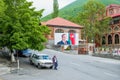 Tired elderly taxi driver waiting for passengers next to his retro soviet car in ancient small town Sheki in Azerbaijan.