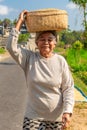 Elderly Balinese Woman Carrying a Basket on Her Head Royalty Free Stock Photo