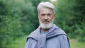 Elderly beard old man portrait in forest nature park. Grandpa face look camera. Royalty Free Stock Photo