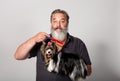 An elderly bearded hairdresser for dogs with a comb and a terrier