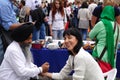 An elderly bearded Indian in a black turban gives a woman an acupressure of the hand Royalty Free Stock Photo