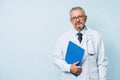 Elderly bearded male doctor in white uniform with a stethoscope with a blue folder. Doctor on the background of a