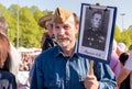 Elderly bearded man with a portrait of his relative in Immortal Regiment on annual Victory Day in the Victory park of Riga, Latvia