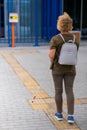 An elderly blind woman goes to a button to call help for people with disabilities. Vertical photo.