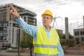 Elderly builder man pointing index finger building background