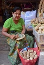 Elderly burmese woman showing how to make fresh Thanaka cosmetic paste Royalty Free Stock Photo