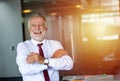 Elderly business man standing confidently smiling and laughing happy in the meeting room Royalty Free Stock Photo