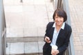 Elderly business woman with coffee, using cell phone, outdoor