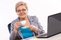 Elderly business woman drinking tea or coffee at desk in office, break at work Royalty Free Stock Photo