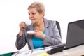 Elderly business woman drinking tea or coffee at desk in office, break at work Royalty Free Stock Photo