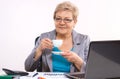 Elderly business woman drinking tea or coffee at desk in office, break at work Royalty Free Stock Photo