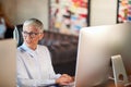 An elderly business woman sitting and working at a desk at workplace. Business, office, job Royalty Free Stock Photo