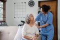 Elderly caregivers are helping to check the health and care for an elderly woman at home. Royalty Free Stock Photo