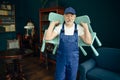 Elderly cargo man in uniform holds child chairs