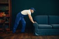 Elderly cargo man in uniform moves sofa