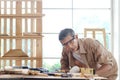 Elderly carpenter wearing safety glasses, working at wooden desk with different craft tools, enjoying his DIY hobby, senior Royalty Free Stock Photo