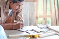 Elderly carpenter working at wooden desk with different craft tools, enjoying his DIY hobby, senior craftsman drawing a design of Royalty Free Stock Photo