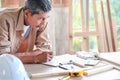 Elderly carpenter working at wooden desk with different craft tools, enjoying his DIY hobby, senior craftsman drawing a design of Royalty Free Stock Photo