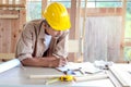 Elderly carpenter working at wooden desk with different craft tools, enjoying his DIY hobby, senior craftsman drawing a design of Royalty Free Stock Photo