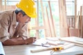 Elderly carpenter working at wooden desk with different craft tools, enjoying his DIY hobby, senior craftsman drawing a design of Royalty Free Stock Photo