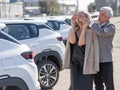 An elderly Caucasian man gives a new car to his beloved woman.