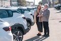 An elderly Caucasian man gives a new car to his beloved woman.