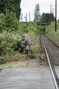 Elderly caucasian man trimming brambles by a train track