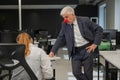 Elderly Caucasian man wearing a clown nose swears at his subordinate in the office. Royalty Free Stock Photo