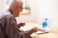 Elderly caucasian retired man talking to young UK female doctor via online video call