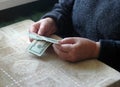 Elderly caucasian woman counting money on table